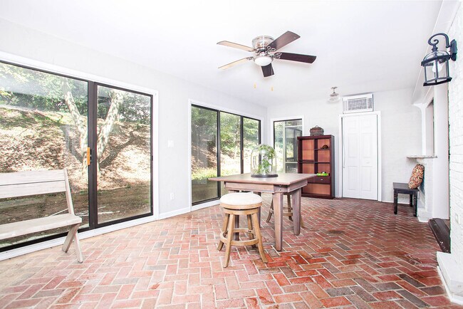 Open sunroom lined with brick-flooring & tons of windows! - 7022 Quail Hill Rd