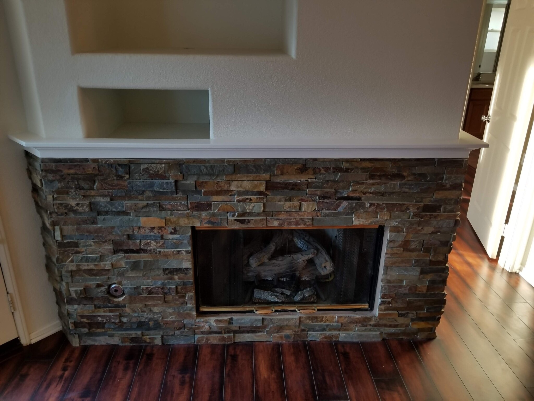 Stacked stone fireplace with gas fireplace insert - 16939 Robins Nest Way