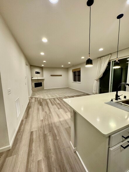 Living room and kitchen, with dual siding doors to back patio - 6750 Skipper Ln SE
