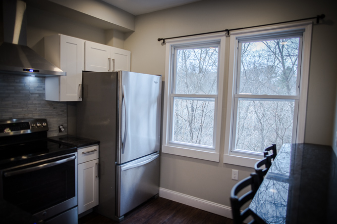 Granite bar with stools for eating next to windows overlooking creek. - 114 Ferris Place