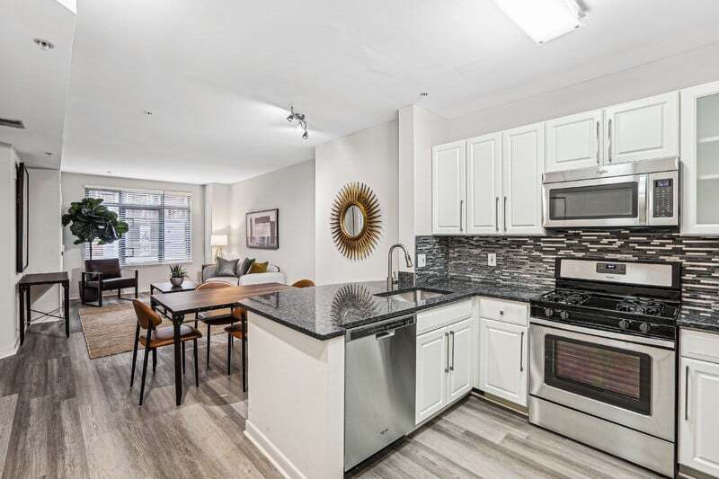 View from Kitchen Toward Bedroom, Dining Table, and Windowed Living Room - The Barton at Woodley