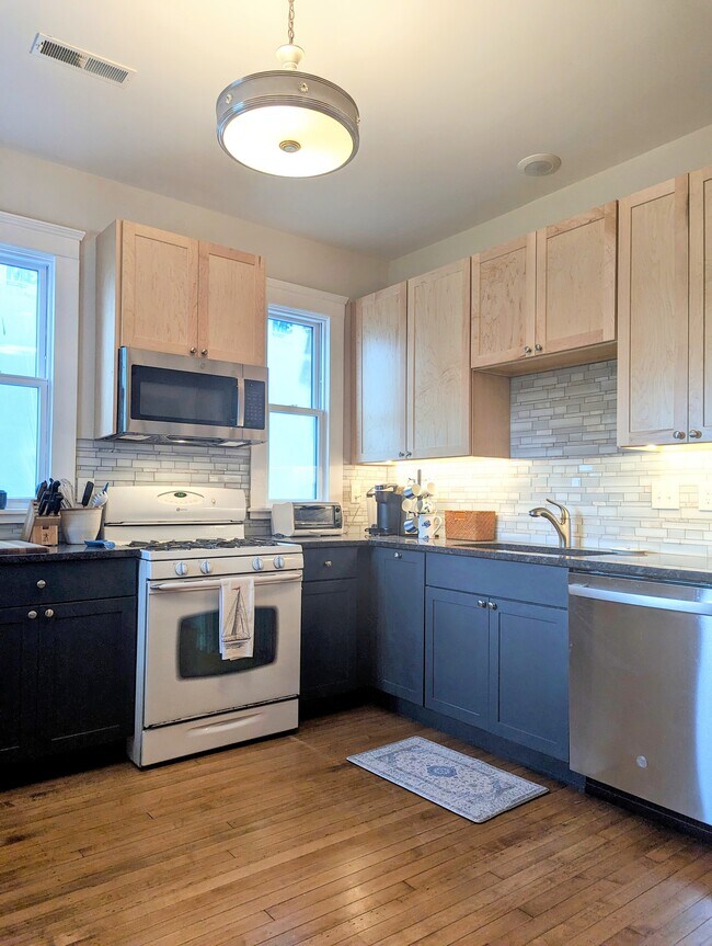 Kitchen with stainless appliances, hardwood floors, granite counters, tiled backsplash - 7216 W Clinton Ave