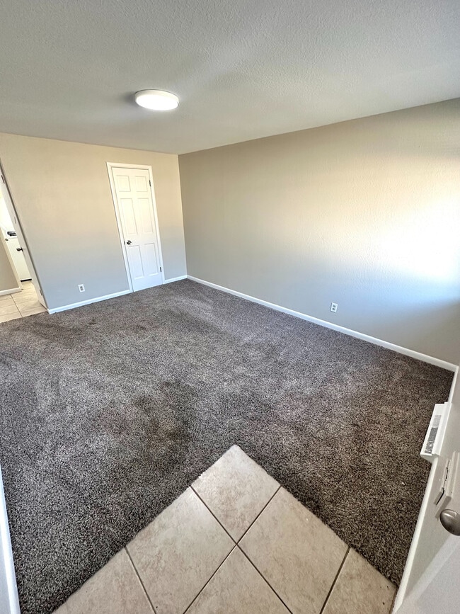 Inviting room with plush carpet, neutral walls, and bright lighting, ideal for a cozy living space. - 7750-7766 West 39th Ave