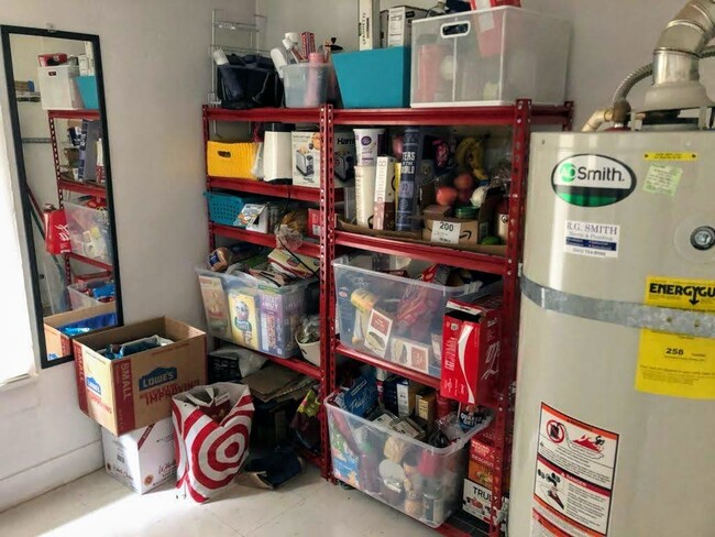 Storage room with gas water heater, just off the kitchen. Turn left and enter bathroom. Red shelves are a newer permanent addition - great for storage - 804 NW 29th St