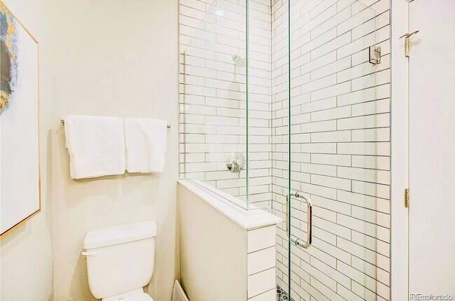 Explore this elegantly designed bathroom, featuring contemporary finishes and a glass shower. - Harley House