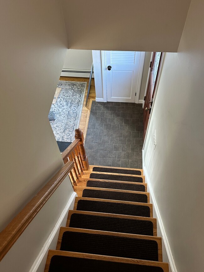 View down stairs to front entry and coat closet - 480 Newington Rd