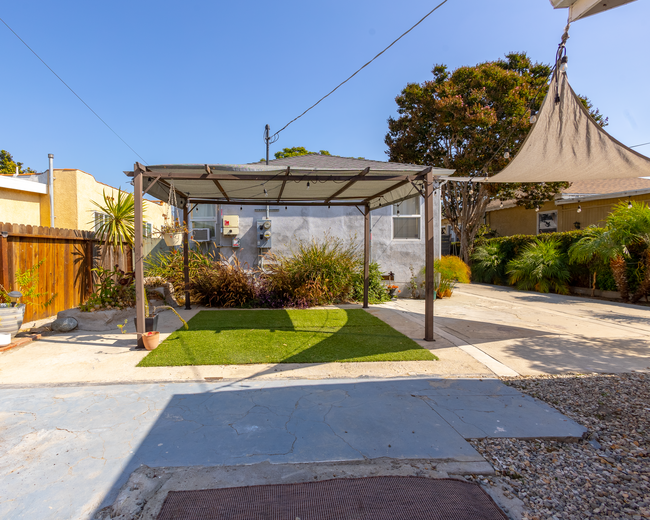 Backyard 1 - Pergoa, string lights and sun shades make this backyard an inviting oasis - 6401 Arlington Ave