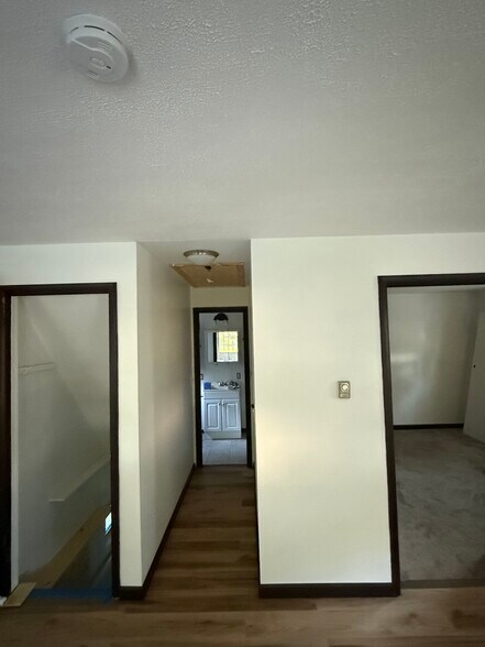 Bedroom #1 on right, Full bathroom down hallway, basement access on left. - 6820 Rowe Dr