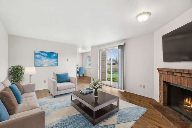 Experience comfort and warmth in this beautifully designed living area with a garden view. - Stillwood Apartments