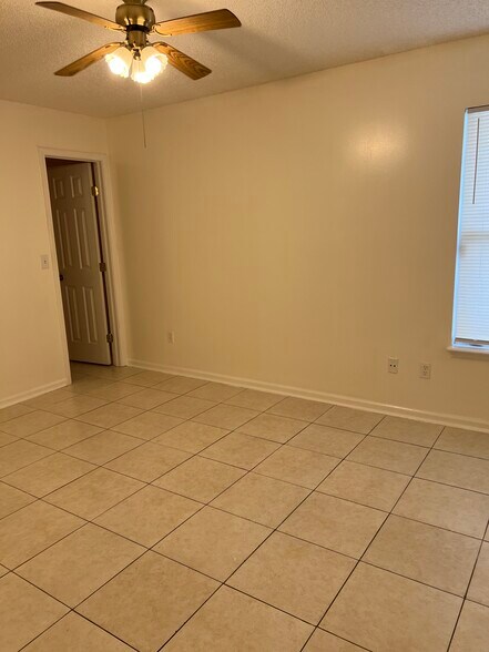 generously sized second bedroom with a walk-in closet and ceiling fan, providing both comfort and fu - 5374 Lacy Jane Way