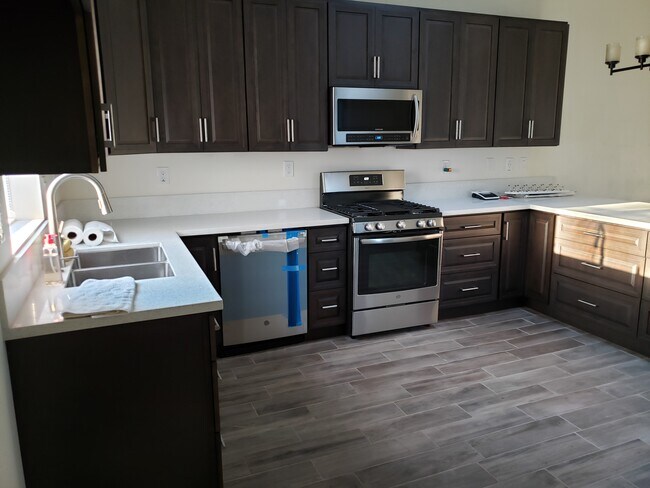 Kitchen with dishwasher, stove, microwave - 417 S Jennifer Ln