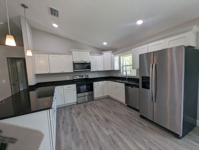 Building Photo - New 3/2/2 fenced home with Many Upgrades i...