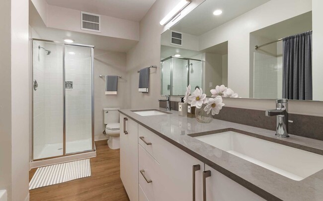 Limited availability: newly renovated Finish Package II apartment homes featuring baths with grey quartz countertops, white cabinetry, and hard surface flooring - Avalon Sunset Towers