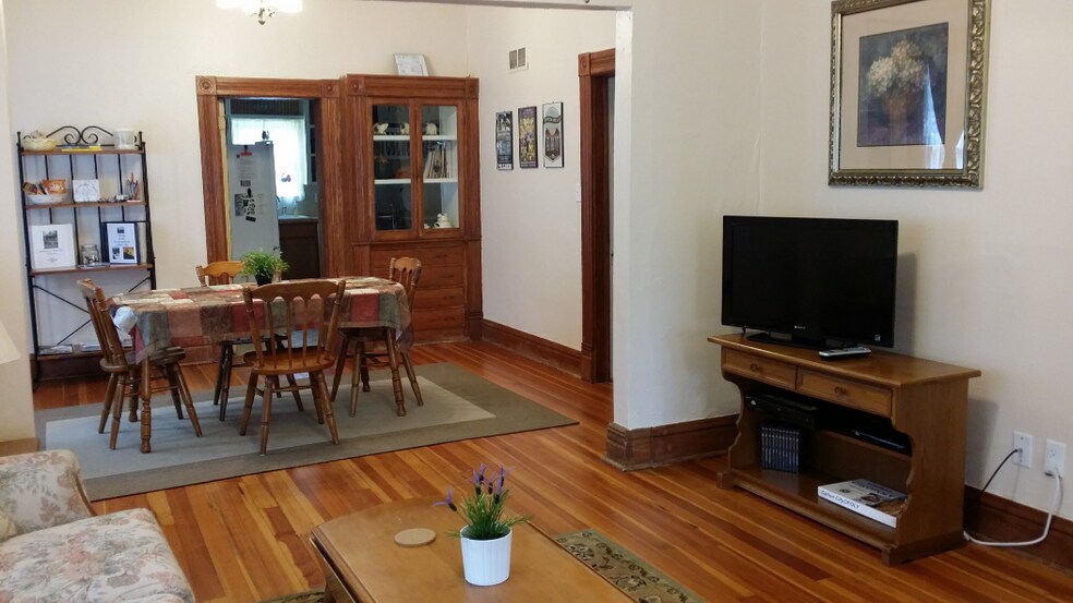 View from middle living room into dining room with built in cabinet and door to back bedroom (furnishings not included with rental) - 607 Harrison Ave