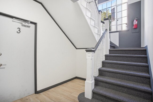 Staircase with carpet and a door next to a stairwell - 2363 Le Conte Avenue