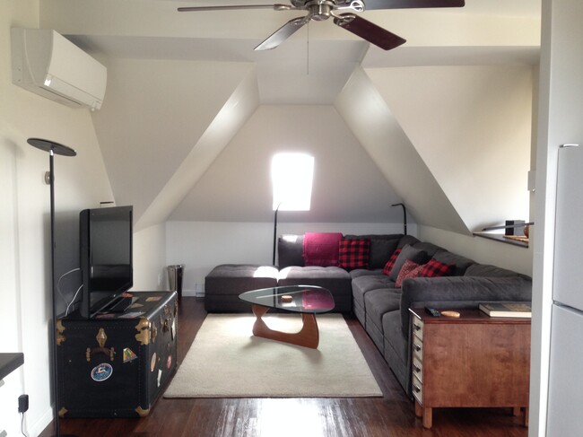 Bright living room with couch, table and TV - 3643 Lincoln St