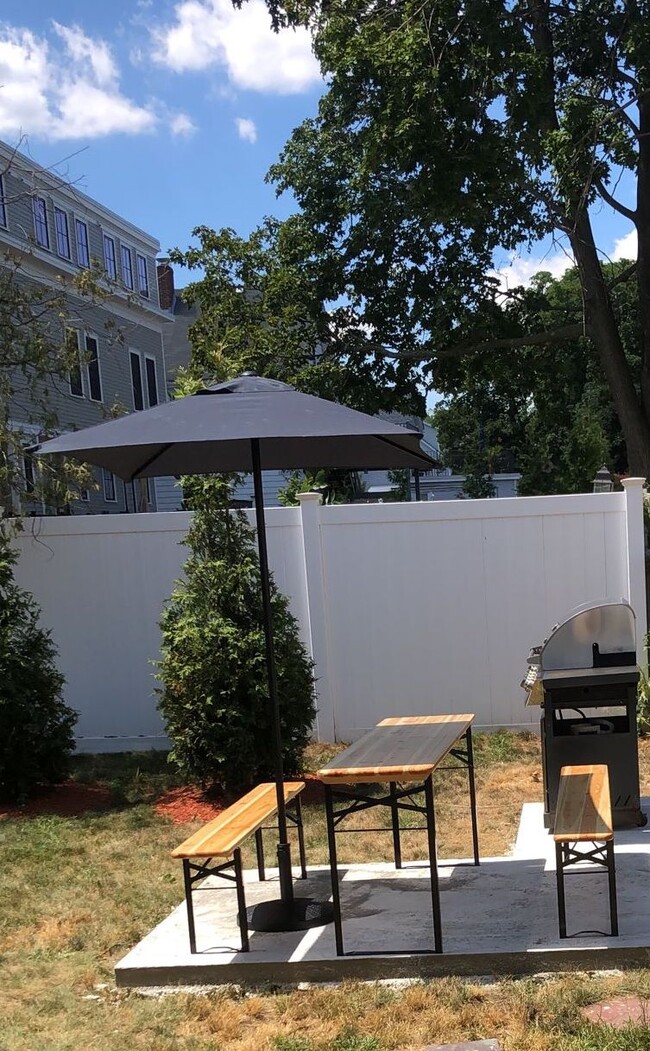 Professionally landscaped backyard with patio. Shared. White vinyl fence throughout. - 58 S Waverly St