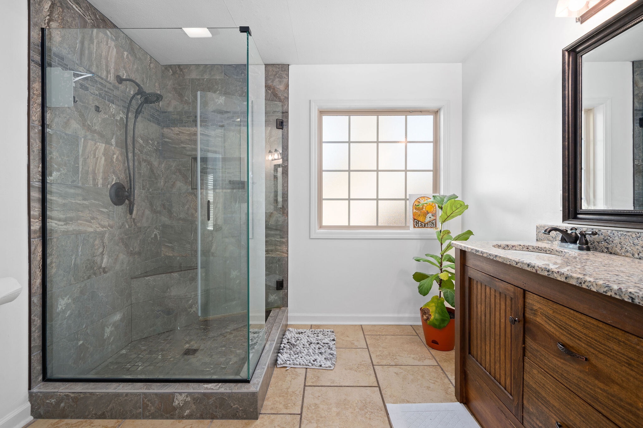 Primary bathroom with walk in shower and a granite countertop. - 525 Parkvue Village Way