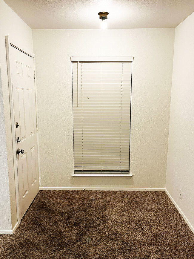 The foyer features a traditional single window for natural light and a wood door with peephole. - 4917 Jamesway Rd