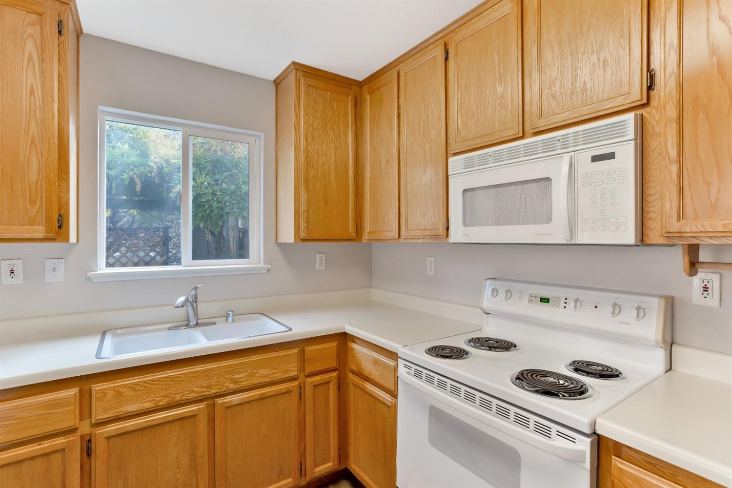 The close view into the kitchen's sink, stove, & microwave. - 3038 Courtside Dr