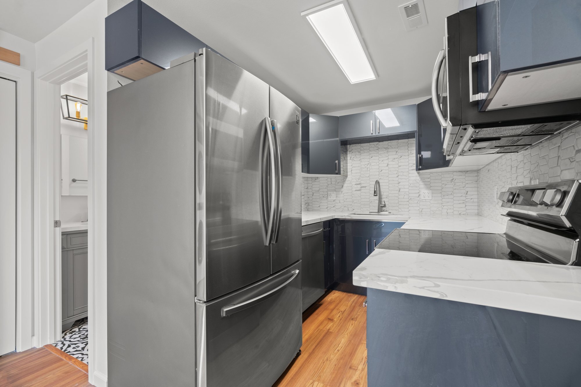 Open-concept renovated modern kitchen with all new stainless steel appliances - 411 124th St S