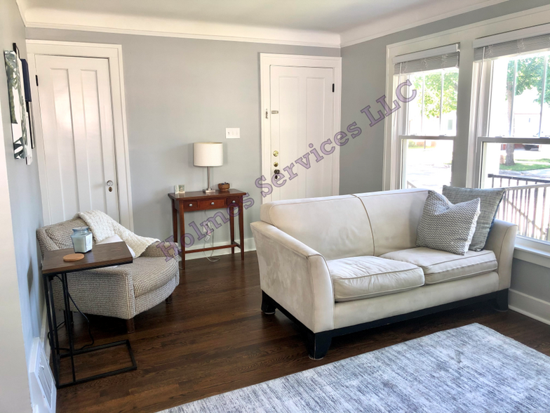 Living room - full wall of windows! Entry door shown on right, storage closet on left. - 526 Academy St