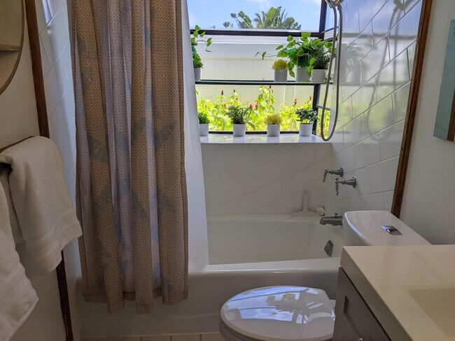 Attached bathroom w/ tub and shower and garden view - 426 Ilimano St