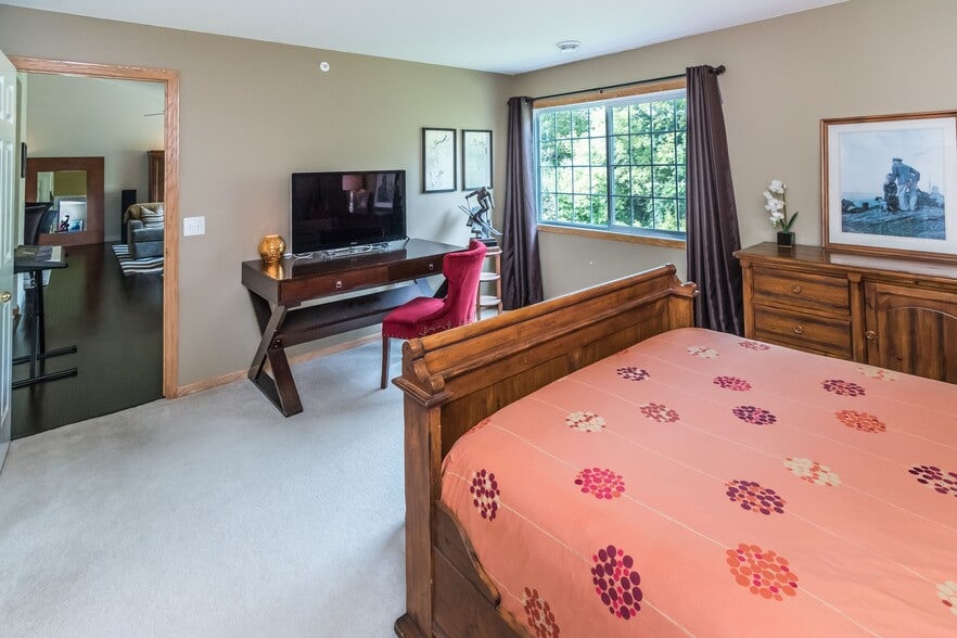 Large primary bedroom with views of trees. - 1102 Bergmann Dr