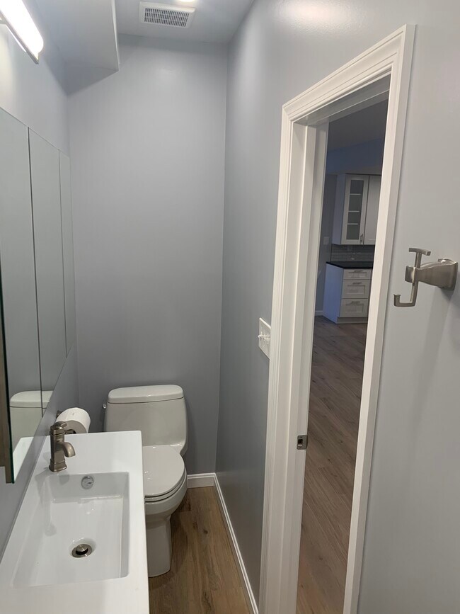 Bathroom 1 with kitchen in background - 4631 Massachusetts Ave NW