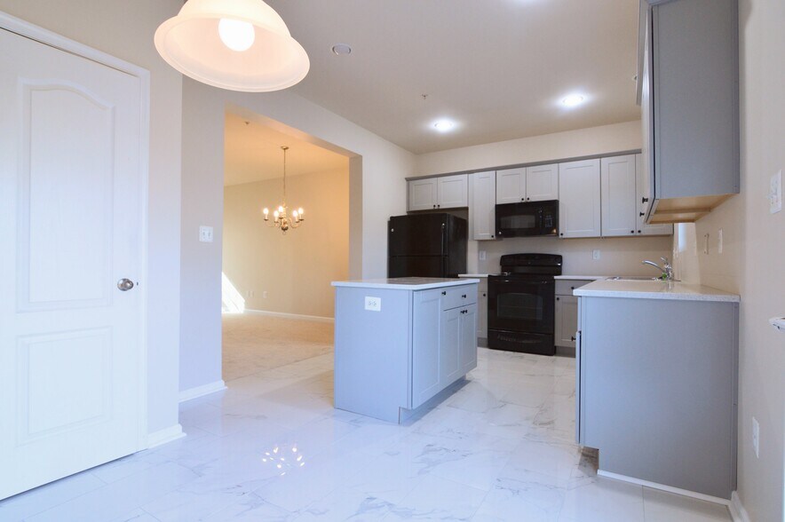 Kitchen with quartz countertops and island - 11696 Palm Desert Pl
