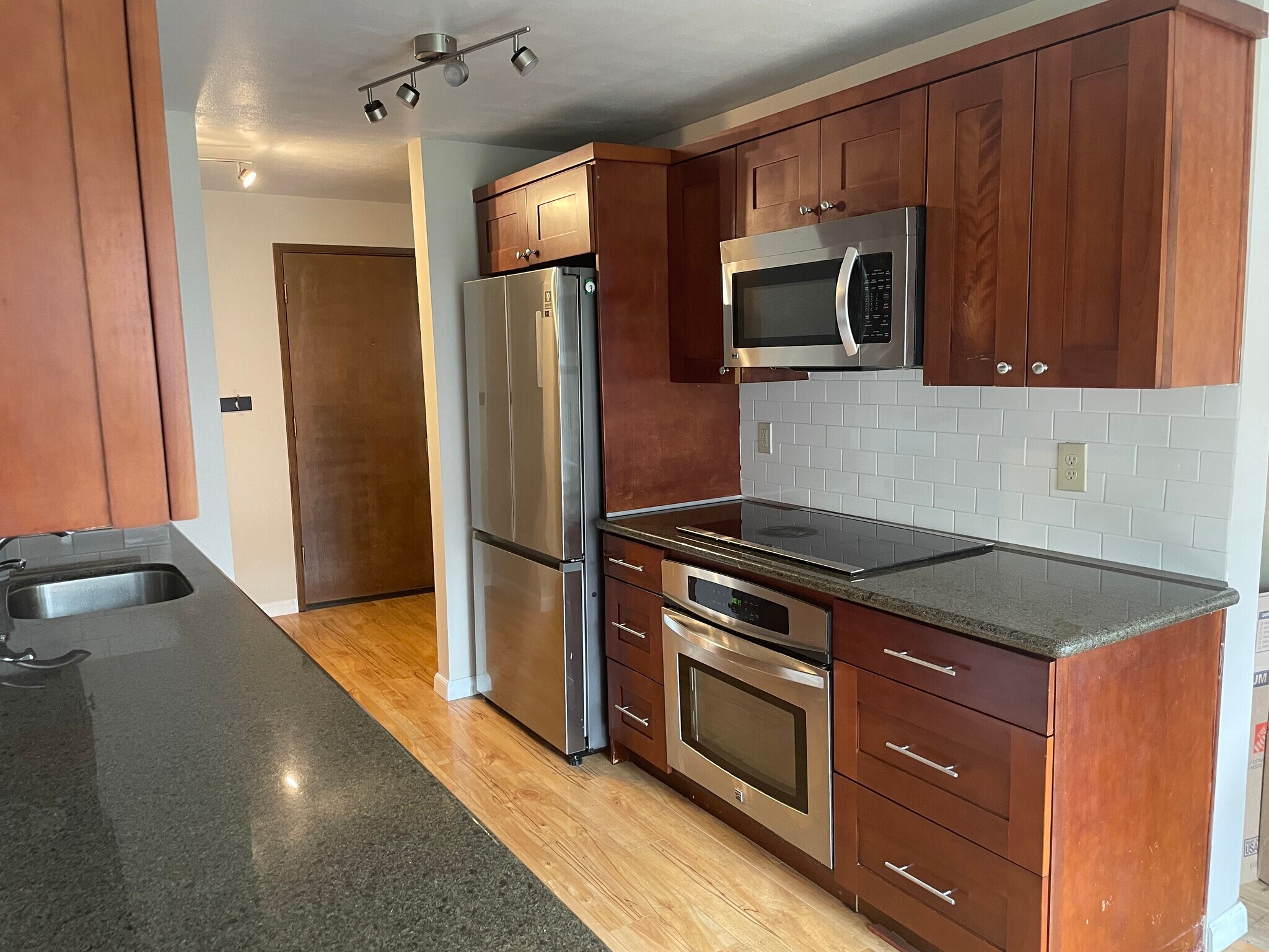 In kitchen. Front door beyond. (facing southeast). (note recent fridge, stove, induction cooktop - 7001 Sand Point Way NE