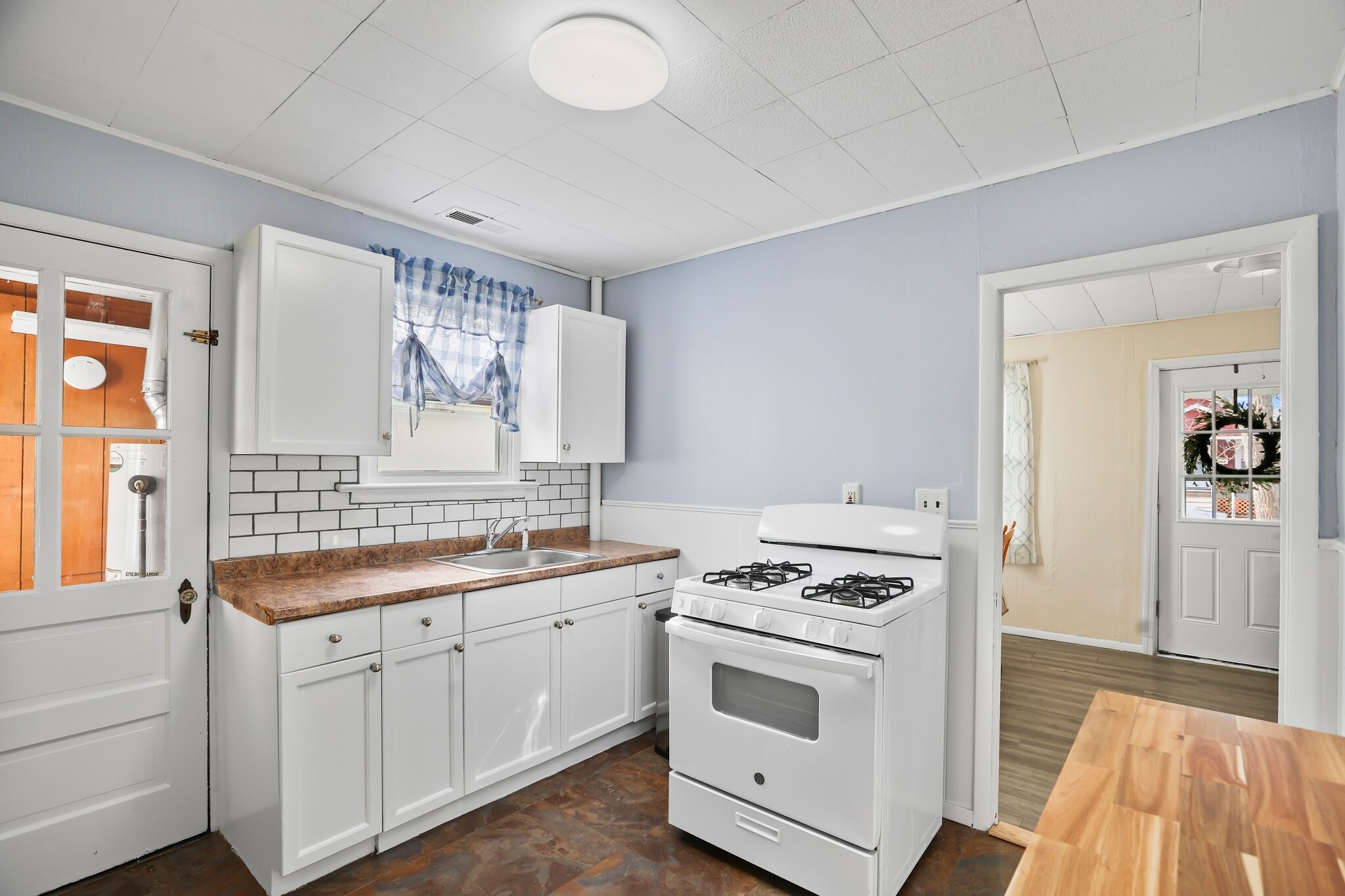 Kitchen with white cabinets and applicances, brand-new tile backsplash, and laminate countertop - 1710 B St