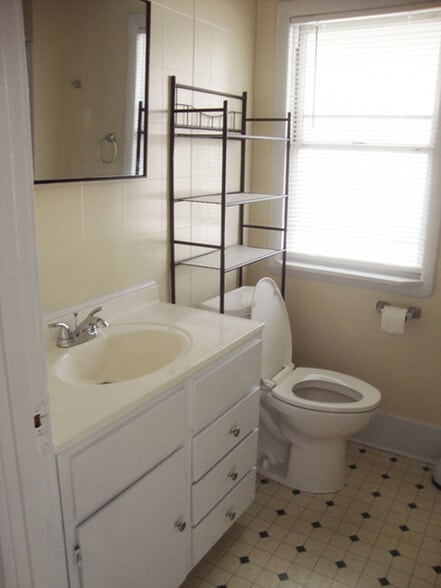 Bathroom vanity and stool, bathtub with shower on right. - 458 McConnell St
