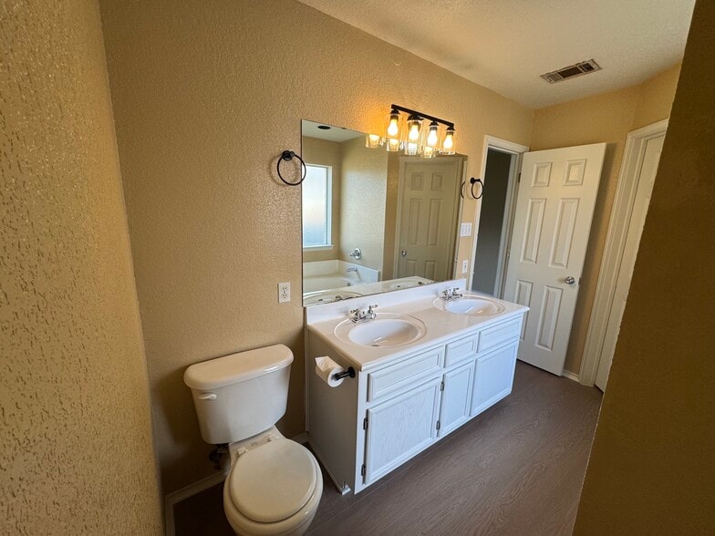 Dual-sink vanity with updated lighting—perfect for busy mornings. - 2806 Maria Dr