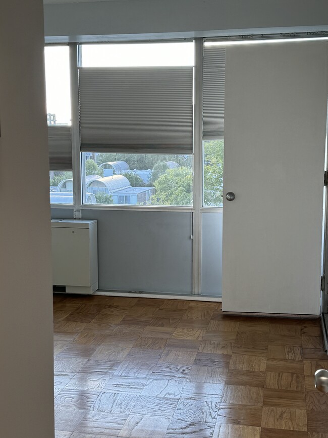 bedroom with shades at multiple drawn points and door to balcony - 1301 Delaware Ave SW