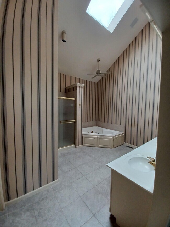 A primary bath with a skylight, garden tub, separate shower, and double vanity is the ultimate in - 6003 N Norton Ave