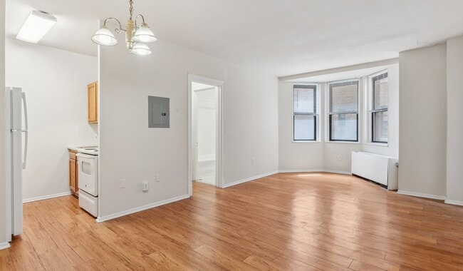 Spacious living space with natural light and wood flooring - Chestnut Hall