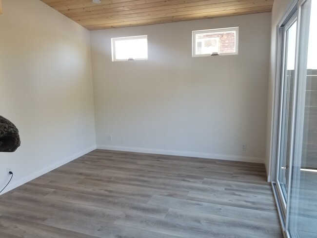 Master bedroom with wood high ceilings, ceiling fan, private courtyard, custom driftwood mantel over - 6832 Zelzah Ave