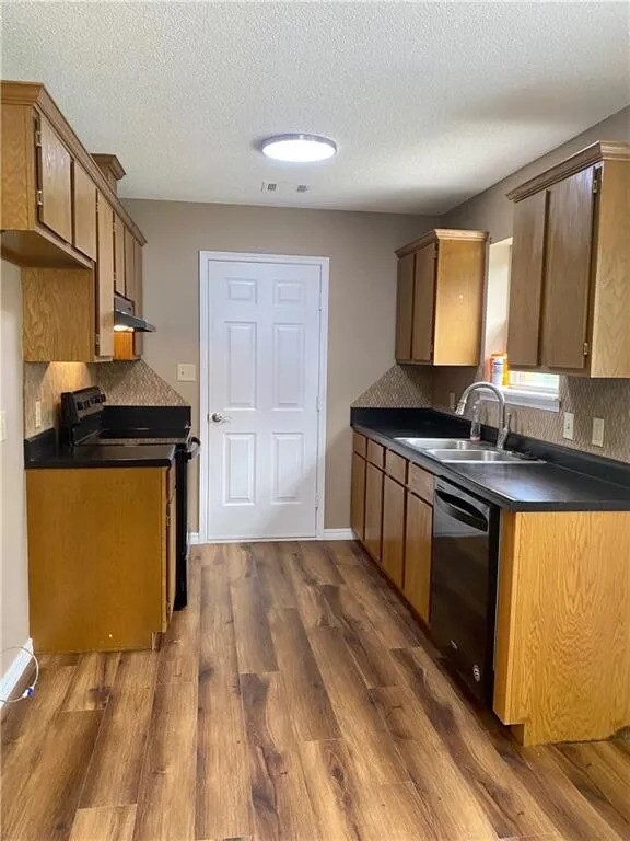 Kitchen with stovetop, range, dishwasher and access to laundry room - 507 Boulder Dr