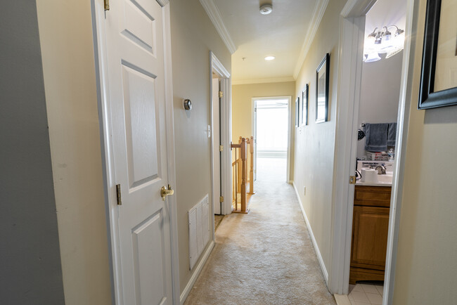 Upstairs hallway, laundry and storage on the left, master bedroom doorway at the end of the hallway away from additional bedrooms for privacy. - 22785 Settlers Trail Terrace