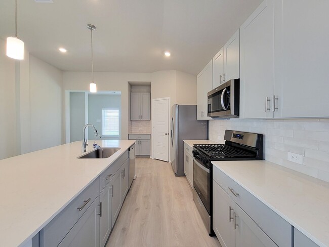 Building Photo - Single-story layout features a bright, open concept living area, dining space, and kitchen. Pebbl...