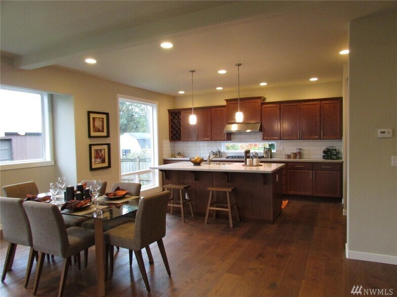 Kitchen and dining rooms. To the right of the kitchen is the walk-in pantry, mud room garage entrance and large closet. To the left of the dining room is the covered patio entrance. - 15828 25th Ave NE