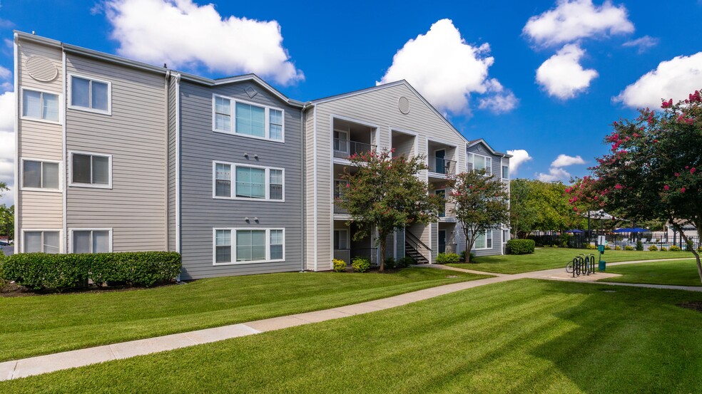 Our community features modern apartment buildings surrounded by lush greenery and vibrant landscaping, perfect for a peaceful living experience. - MAISON Burbank