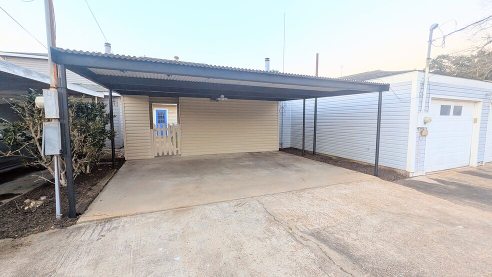 Back alley drive leads to this large carport for residents. - 813 Clubside Dr