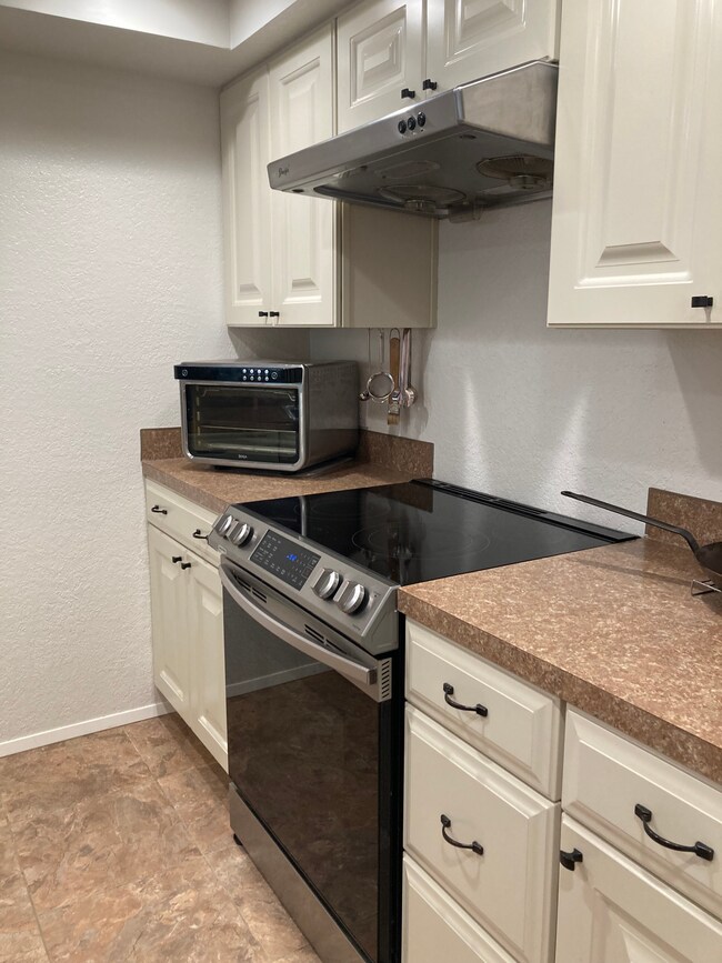 Kitchen (right). New electric cook top and oven. Range hood above. - 6 Lake Bellevue Dr