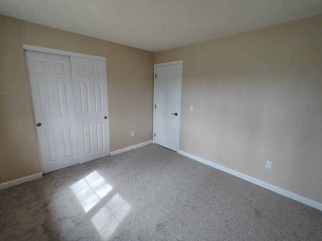 Guest bedroom with new closet doors, baseboard, carpet, switches, and outlets - 9 Kenmar Dr