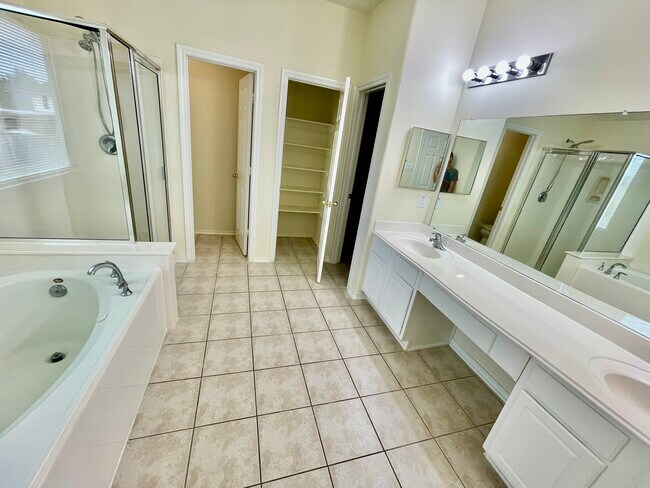 Primary bathroom including garden tub, shower, double sink, separate restroom, convenient storage. - 18911 Piney Bend Ct