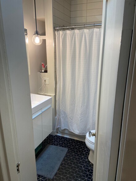 the other bathroom, equally beautifully tiled, rejuvenation fixtures & luxe skylight way up high - 5124 NE 35th Pl