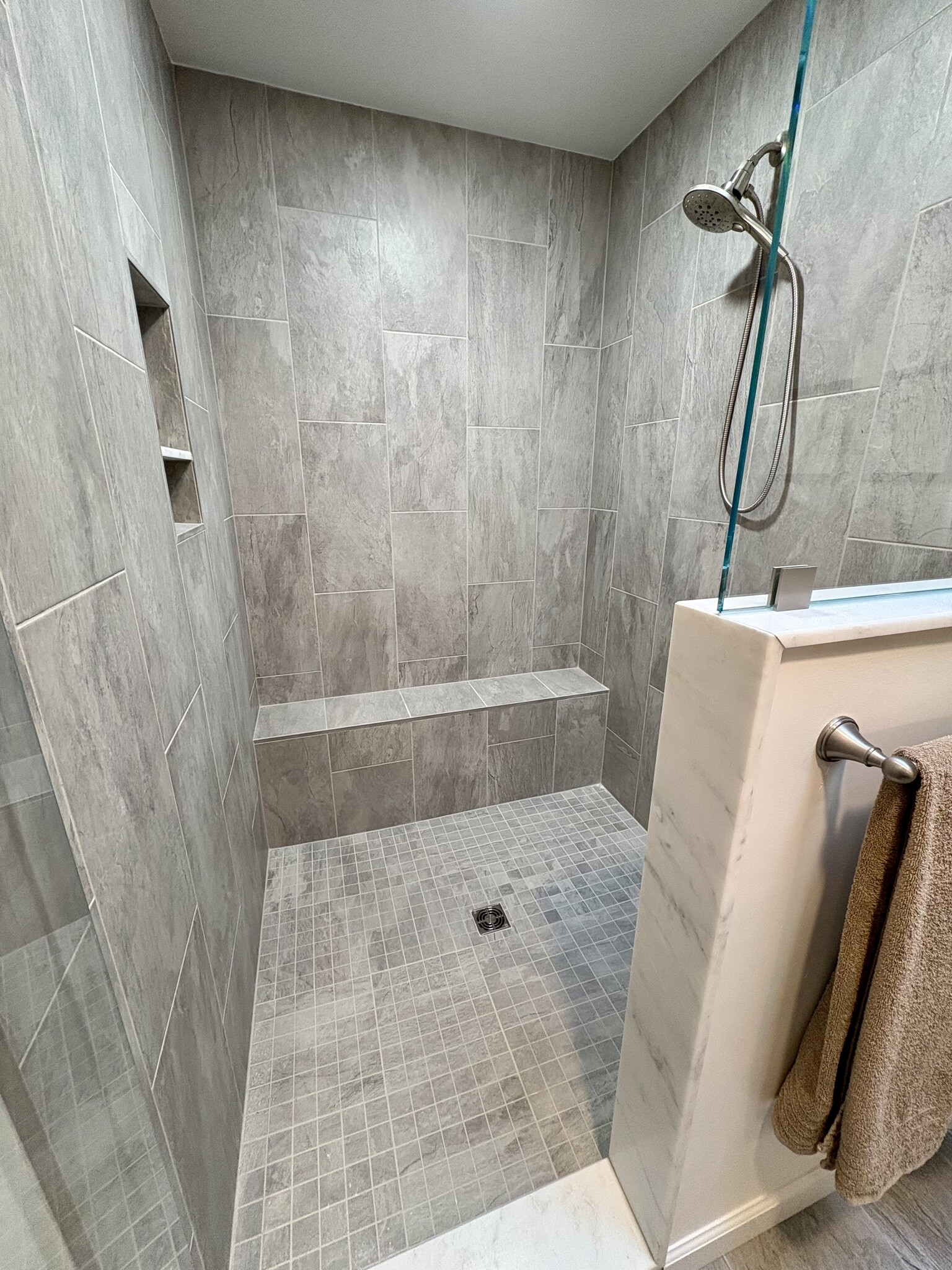 Huge tile shower features a built in bench and magnetic shower head that can convert to a handheld s - 683 Richies Way