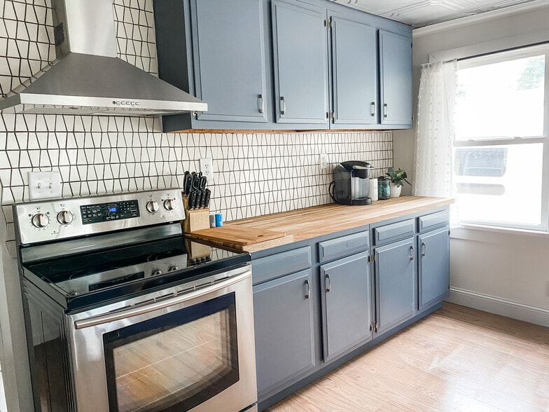 Kitchen with stainless steel appliances, butcher block counters, and custom tile back splash. - 1012 Englewood Ave